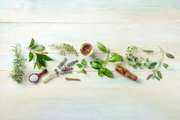 Fresh herbs, shot from the top on a wooden background with salt and pepper. Rosemary, lavender, bay...