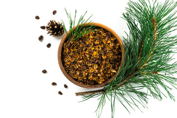 Pine nuts shell in the bowl, cedar branch, nuts  and cones isolated on white background