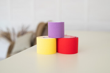 Set with different color kinesio tapes on pastel background. Kinesiology, physical therapy, rehabilitation concept