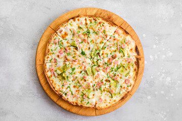 Thin-crust pizza dough with shrimps and slices of zucchini