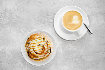 Cappuccino and rolled bun with caramel