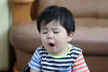 目を閉じてあくびをしている男の子の赤ちゃん