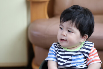 あごを歪めて変顔をする男の子の赤ちゃん