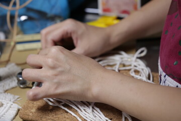 マクラメ編みでタペストリーを作成している手