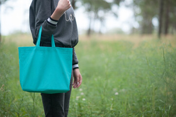 Young woman holding emerald green tote bag