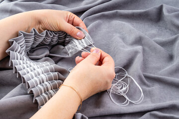 Close up of woman hands hanging curtain
