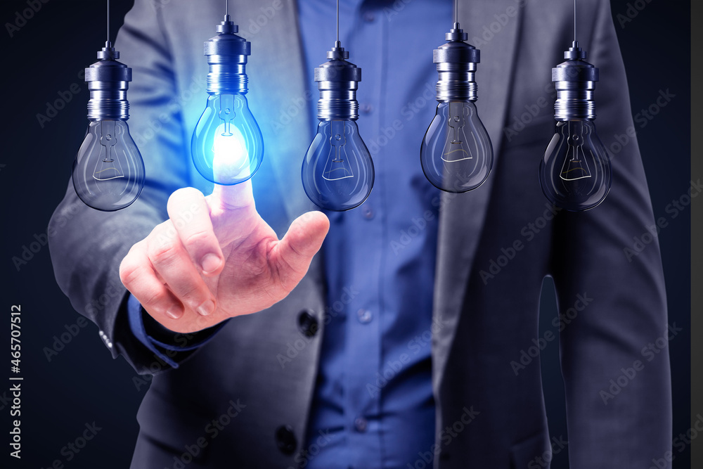Poster close up of businessman hand pointing at abstract glowing row of light bulbs on dark background. ide