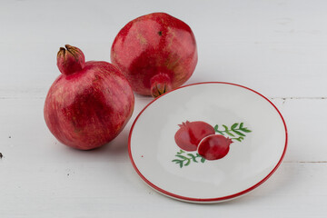 pomegranate fruit with turkish jewellery and open pomegranate on an red, side view