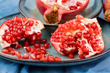 Fresh juicy ripe pomegranate on a wooden background, close-up. Pomegranate fruit, cut in half