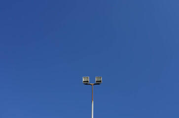 Photo of a sports lantern on a sports field against a blue clear sky