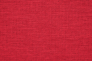 Close-up of a dark red woven surface. The texture is similar to linen. Fabric background for Christmas or New Year. Textured woven backdrop