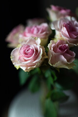 White and pink roses in a vase on the rack. Fresh flowers.