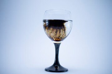 Dark brown food coloring diffuse in water inside wine glass with  for slogan or advertising text...