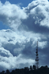 Fototapeta na wymiar Backlit telecommunications antenna on a dramatic cloud day