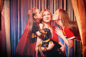 Family during a stylized theatrical circus photo shoot in a beautiful red location. Models mother...