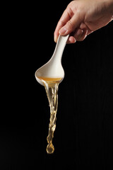 Spoon pouring noodle soup isolated on black background