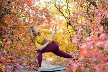 Woman make yoga stretching exercises in forest