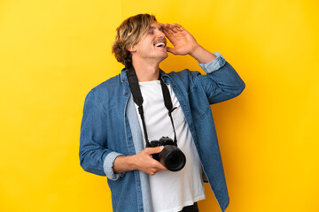 Young photographer man isolated on yellow background smiling a lot