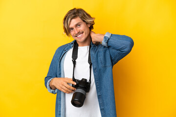 Young photographer man isolated on yellow background laughing