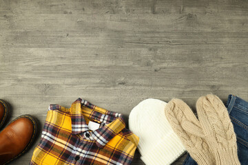 Concept of winter clothes on gray wooden table