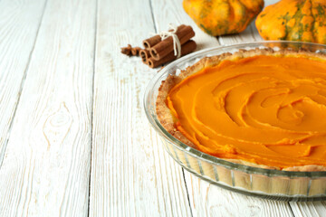 Concept of tasty food with pumpkin pie on white wooden background