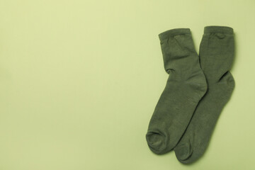 Pair of green socks on green background