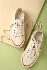 Pair of beige sneakers on two tone background
