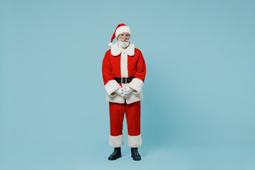 Full body calm old Santa Claus man 50s in Christmas hat red suit clothes posing look camera isolated on plain blue background studio. Happy New Year 2022 celebration merry ho x-mas holiday concept