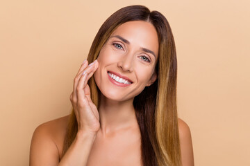 Portrait of attractive cheery long-haired woman touching soft skin lifting laser peeling effect...