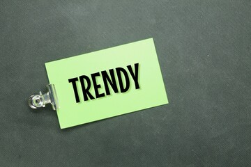 Green paper clamped with the word trendy