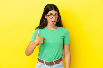 Young caucasian woman isolated on yellow background with surprise facial expression