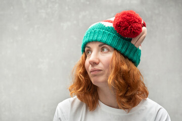 Pensive red-haired woman in elf hat with funny ears. Portrait of side view.