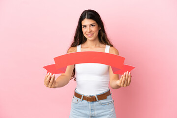 Young caucasian woman isolated on pink background holding an empty placard