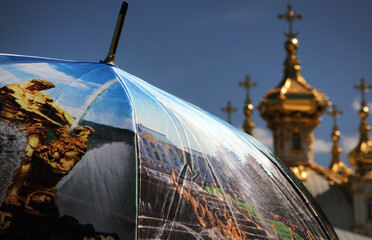 an open umbrella with drawings of a baroque park on the background of the orthodox church