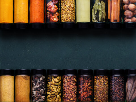 Spices and spicy banner. Colorful various spices in glass jars, copy space, top view.