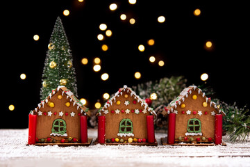 Christmas gingerbread house and Christmas lights on wooden table