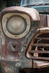 front of an old rusted American car with headlight