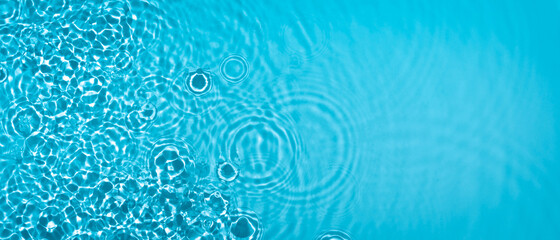 Transparent blue clear water surface texture with ripples, splashes and bubbles. Abstract summer...