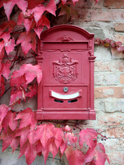 Red vintage postbox on the brick wall
