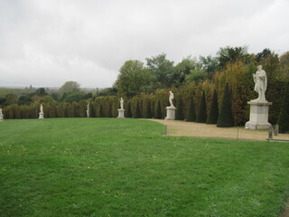 Walk in the evening park. Panoramic landscape with fountains and elegant marble statues in the...