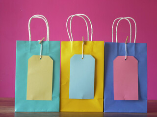 Row of gift bags and labels on pink background