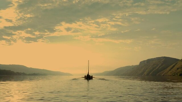 Aerial Filming. A Medieval Ship with Vikings on Board, Sailing in the Middle of the River in a Magical Fog to new Shores. Romanticism Concept.