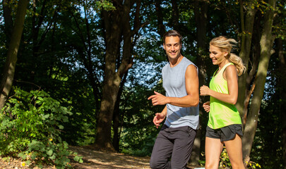 Naklejka na ściany i meble Handsome couple jogging together in the nature