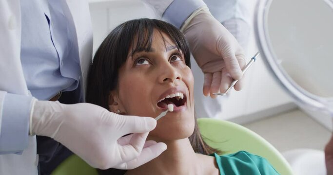Male dentist examining teeth of female patient at modern dental clinic