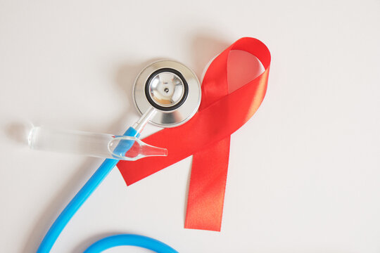 Red ribbon and blue medical stethoscope Healthcare and safe sex concept.