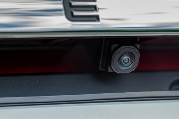 Close up view of rear view parking assist video camera on the car. Modern rear view cameara on modern car trunk. Parking assistant system.