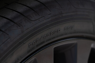 Close up view of tire with tire width, height and wheel diameter designation. Tire size types labels.