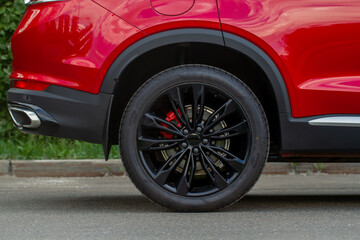 Obraz na płótnie Canvas A close up of wheel disk and the side of car. Car wheel on a car.