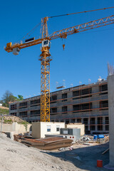 construction site during the erection of a building with reinforced concrete and construction crane