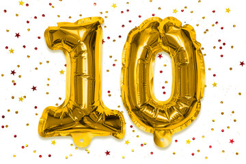 The number of the balloon made of golden foil, the number ten on a white background with multicolored sequins. Birthday greeting card with inscription 10. Anniversary concept. Celebration event.